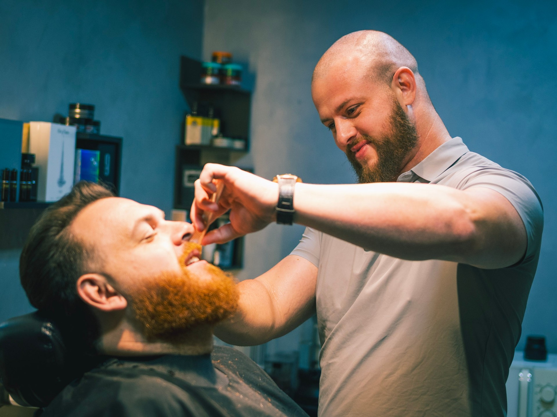 Barbeiro do Cabral Barber Studio aparando a barba de um cliente